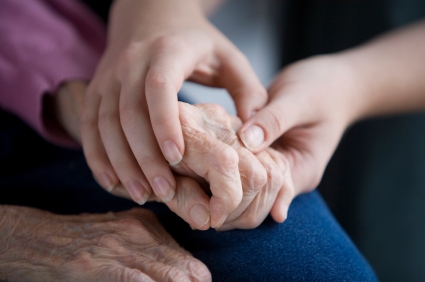 older person holding hands with a younger person
